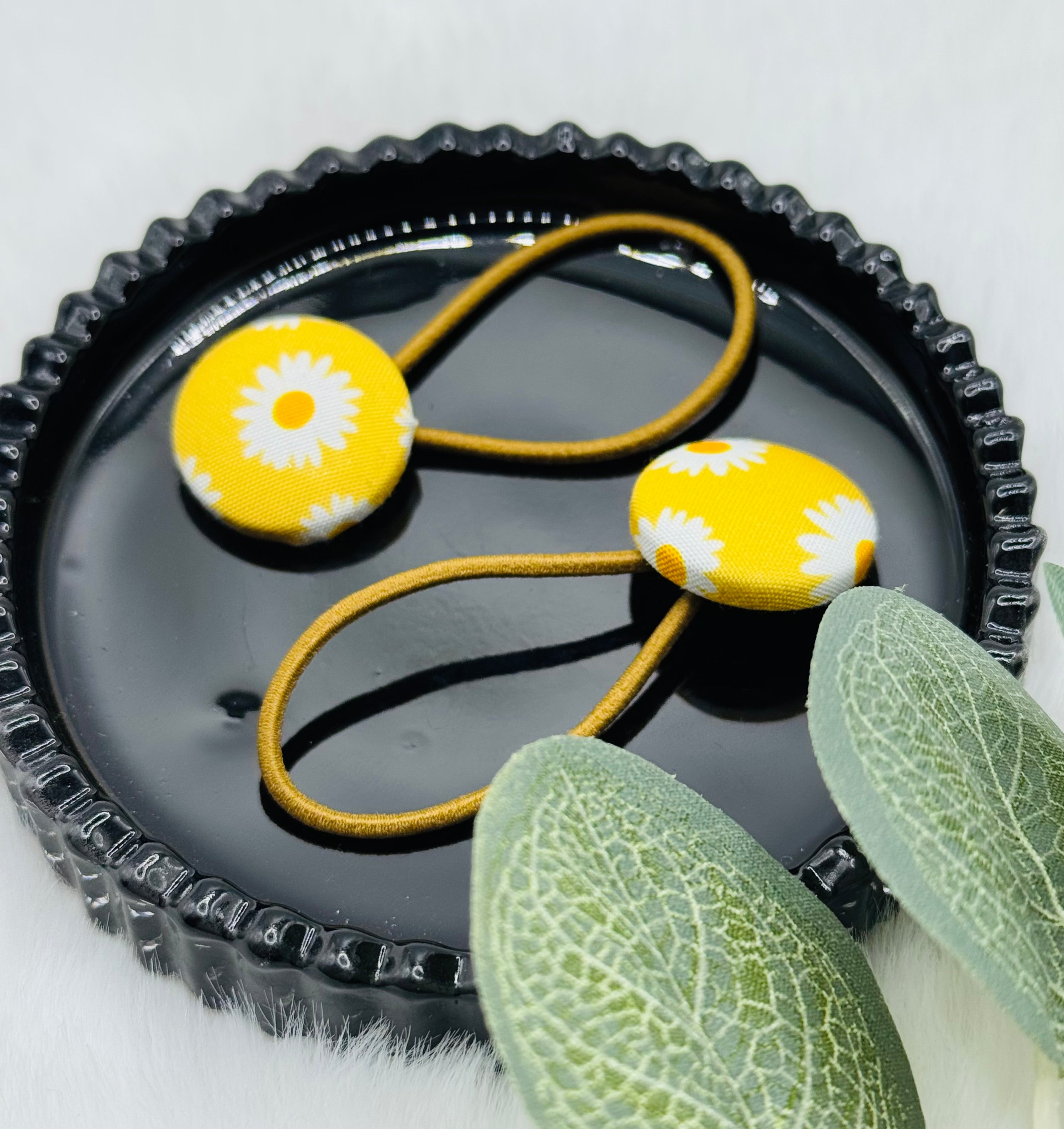 Gelber Haargummi mit weißen Blumen