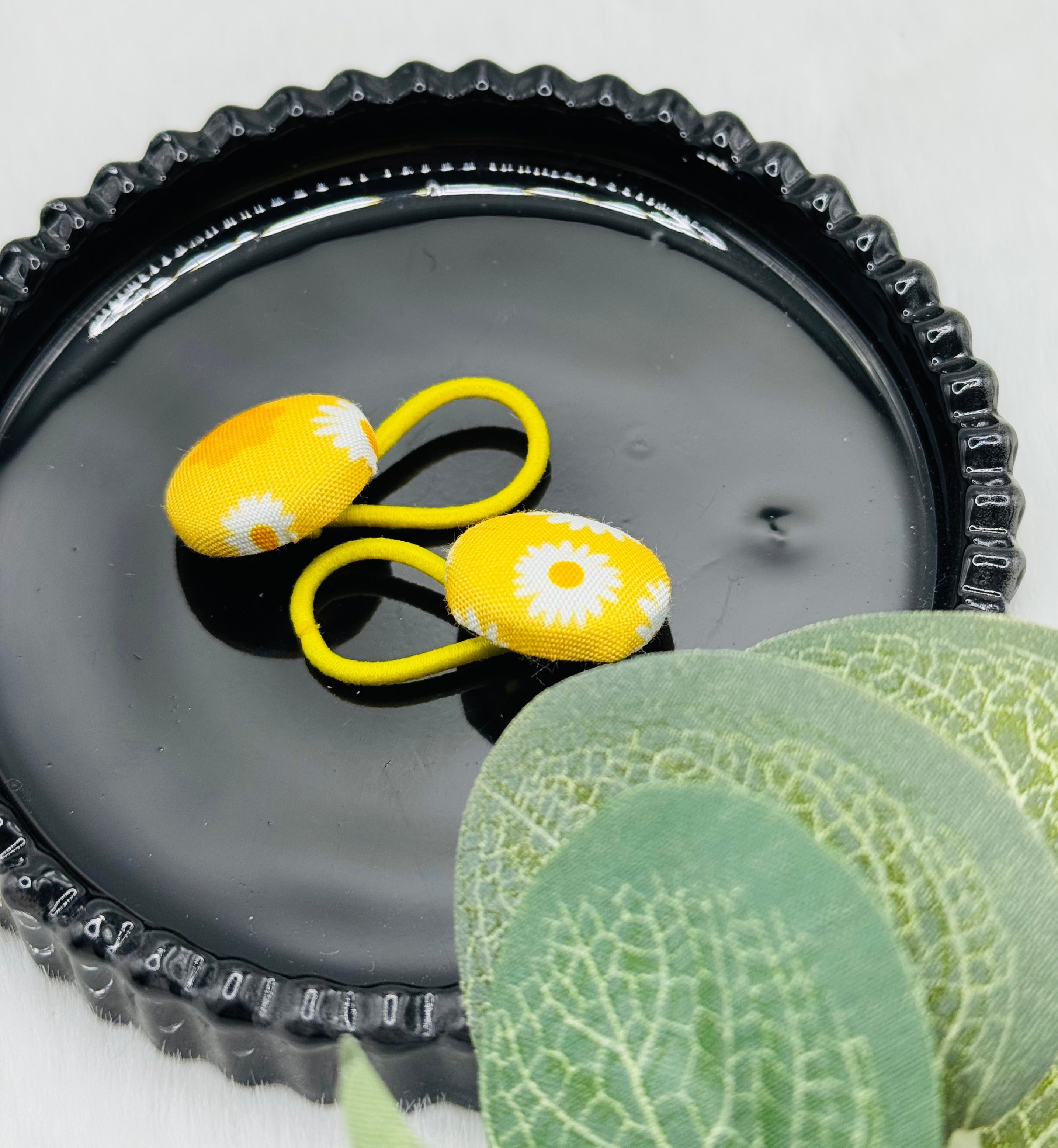 Gelber Haargummi mit weißen Blumen